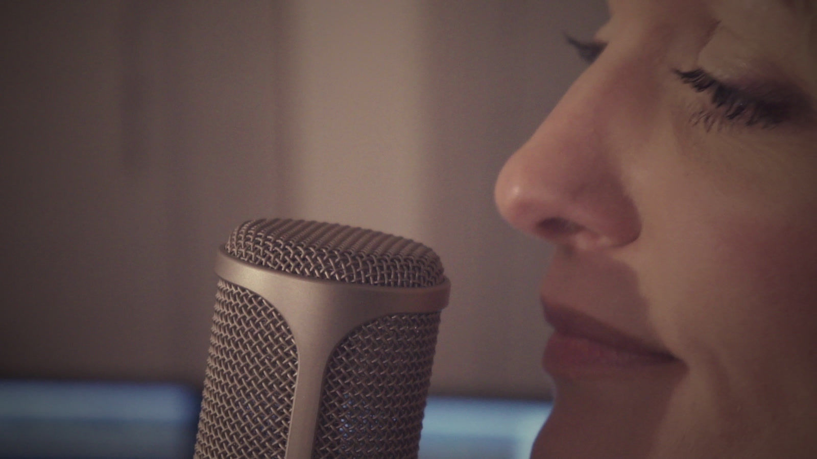 Sophie singing into the microphone, eyes closed